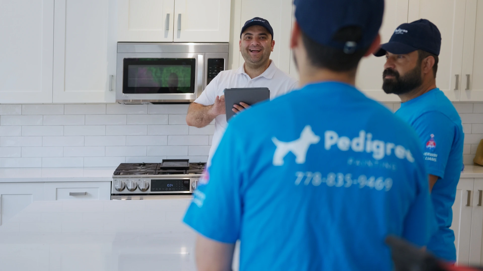 Pedigree Painting team discussing a painting project in a kitchen